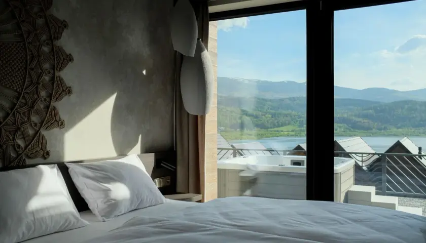 Pokój w hotelu Lake Hill z widokiem na jezioro i góry. Wanna z hydromasażem na tarasie.