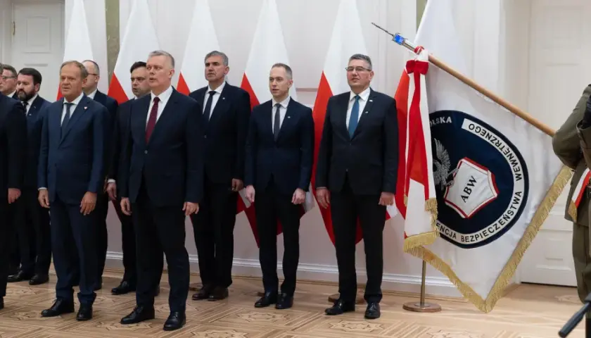 Uroczystość z udziałem premiera Tuska we Włocławku. W tle flagi Polski i ABW.