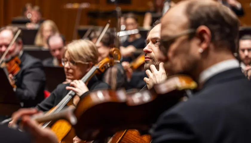 Musiker i orkester spelar cello och fiol. En del av Berwaldhallen program.