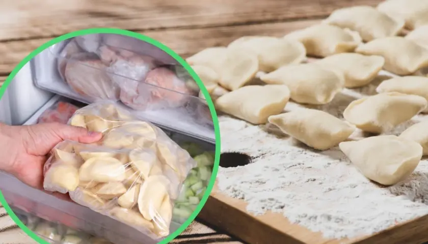 Ręka wkłada do zamrażarki worek z surowymi pierogami, obok leżą uformowane pierogi na desce.