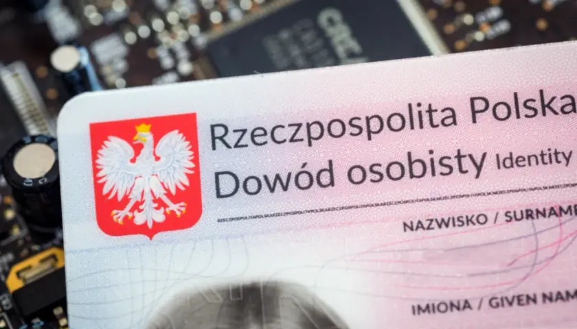Polski dowód osobisty, z orłem w koronie, leży na płytce drukowanej. To ważny dokument, nawet tymczasowy dowód dla dziecka.