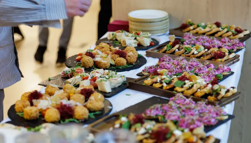Pyszny catering na święta bożego narodzenia: przekąski z kulkami serowymi, rolkami i kanapeczkami z różowymi kiełkami.