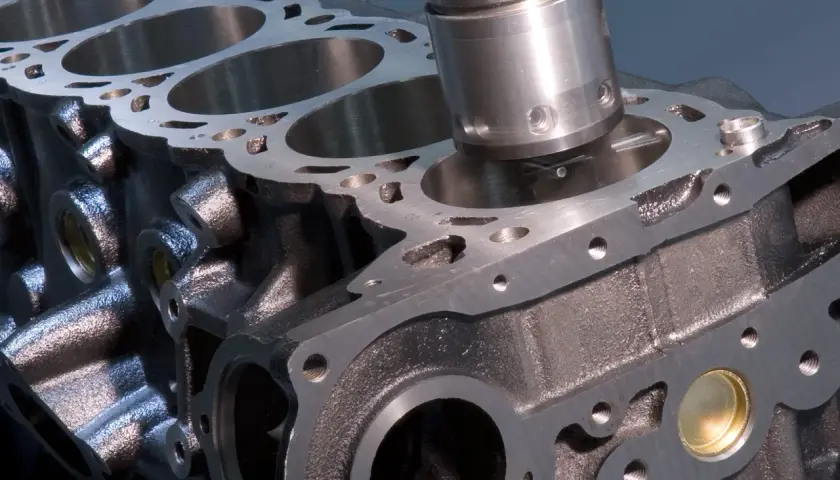 Máquina rectificando un cilindro de motor. El proceso de rectificación es clave para evitar las consecuencias de una culata dañada, asegurando el rendimiento.