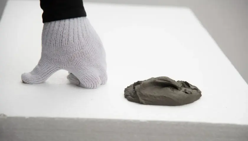 Rękawica na białym styropianie, obok masa szpachlowa. Idealny styropian na podłogę pod wylewkę.