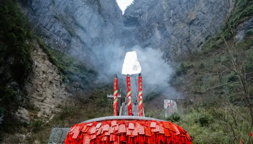 Un gran incensario con amuletos rojos cuelga ante la **puerta del cielo china**, una abertura natural en la montaña.