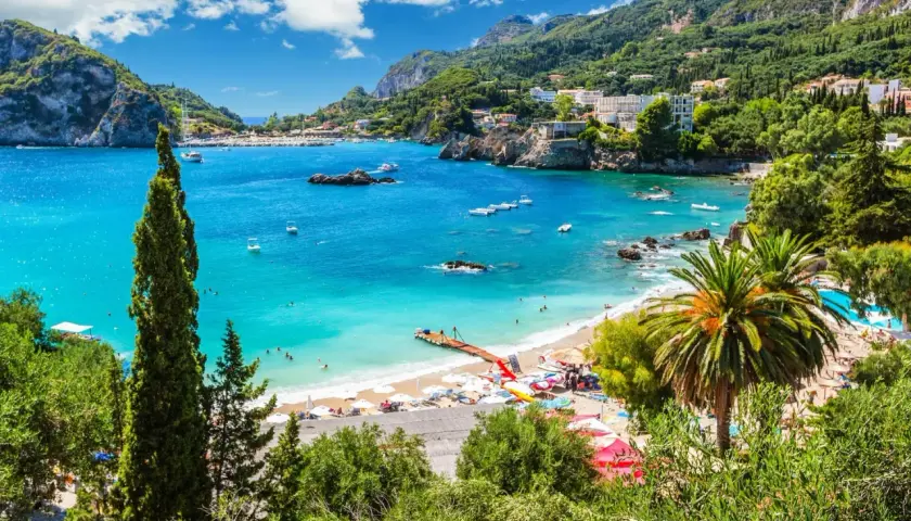 Traumhafte Bucht mit türkisfarbenem Wasser, Palmen und einem Steg. Perfekt für Korfu Reisetipps und einen entspannten Urlaub.