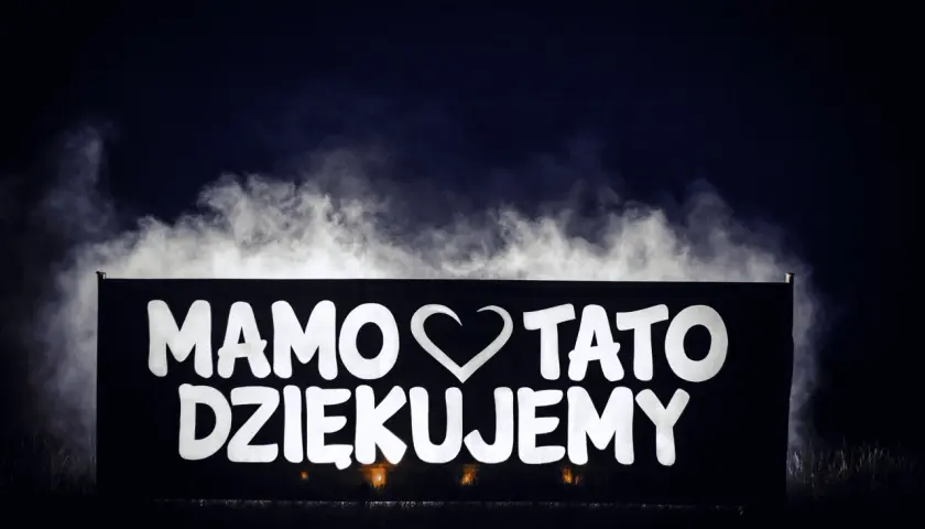 Napis "Mamo, tato, dziękujemy" na banerze, otoczony mgłą. Wspaniałe podziękowania dla rodziców pomysły na wyjątkowy gest.