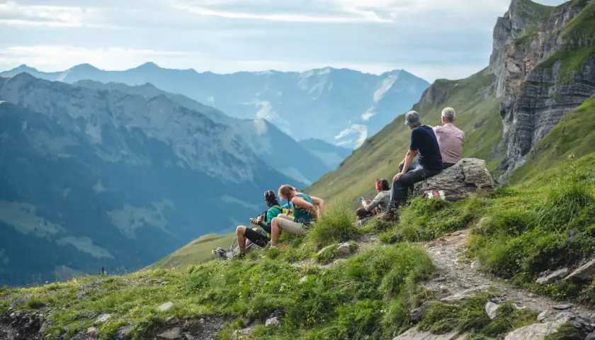 Gruppe genießt die Aussicht beim **Schweiz wandern** in den Bergen.