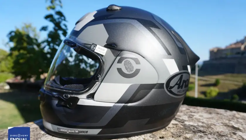 Casco moto Arai con grafica camouflage, conforme alla normativa casco moto. Certificazione E4 visibile.