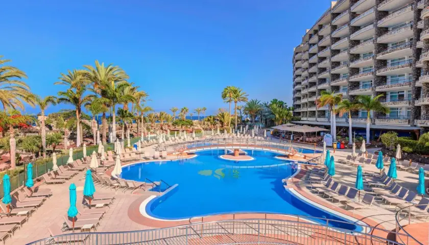 Luksusowy hotel z basenem i palmami, idealne miejsce na wakacje nad morzem. Anfi del Mar zaprasza!