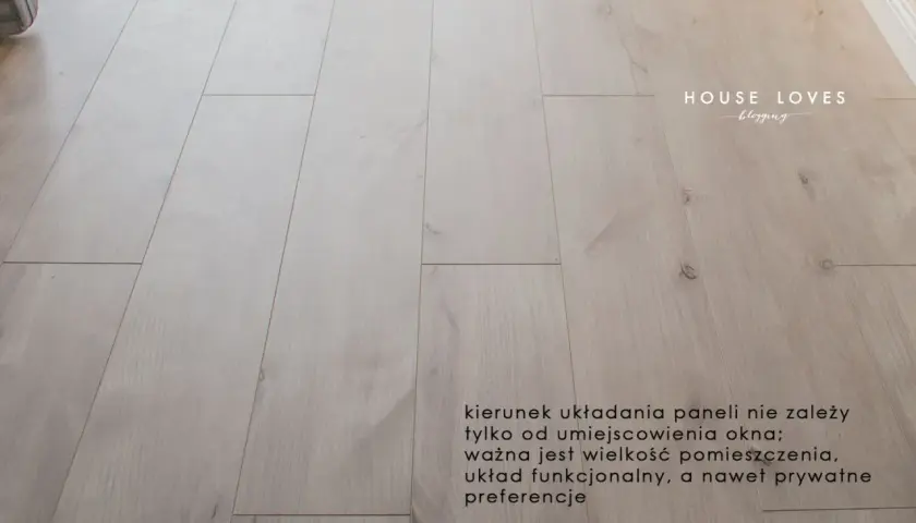 Jasne panele podłogowe ułożone równolegle do okna.