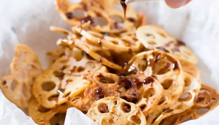 Crispy lotus root chips drizzled with a dark sauce, a simple and delicious addition to your easy Japanese recipes.