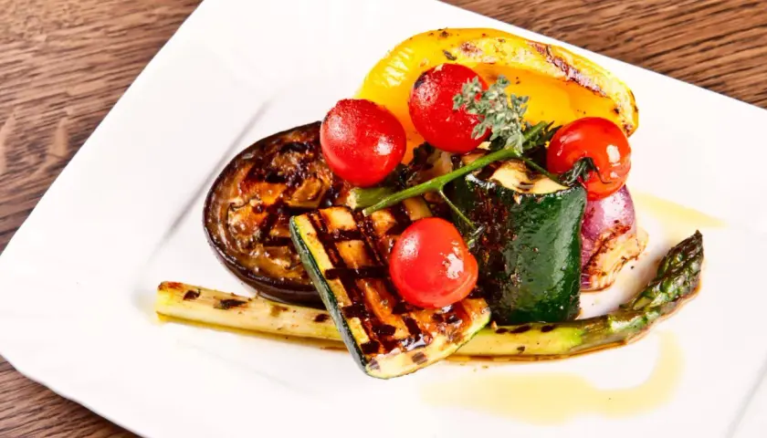 Légumes grillés au barbecue : courgettes, aubergines, poivrons, asperges, oignons rouges et tomates cerises.