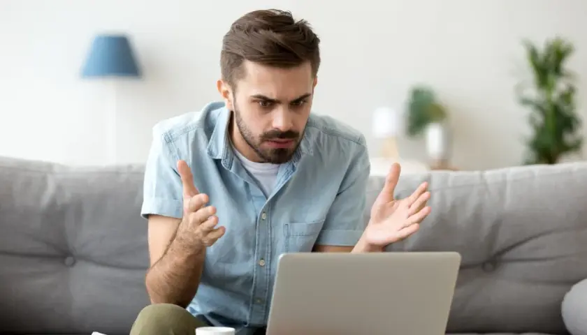 Homme perplexe devant son ordinateur, découvrant une augmentation Deezer inattendue.