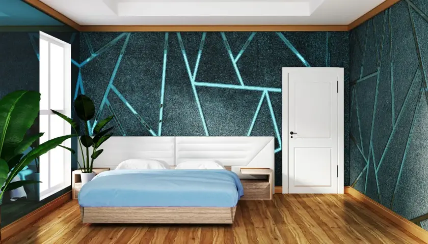 Camera da letto con un letto blu e una testiera bianca. Le pareti presentano una pittura geometrica con un motivo a forma geometrica e linee luminose.