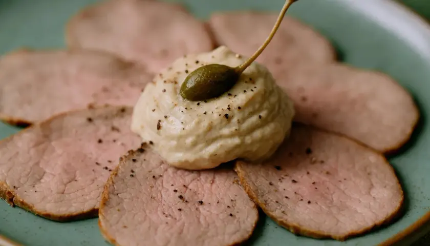 Dünne Scheiben Kalbfleisch, garniert mit einer cremigen Sauce und Kapern. Ein klassisches Vitello Tonnato Rezept, das Appetit macht.