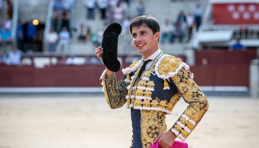 Fco José Espada, torero con traje de luces dorado y azul, saluda al público en la plaza.