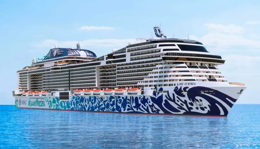 Rejsy po fiordach norweskich z Polski statkiem MSC Euribia. Ogromny statek wycieczkowy z niebieskimi zdobieniami na kadłubie płynie po spokojnym morzu.