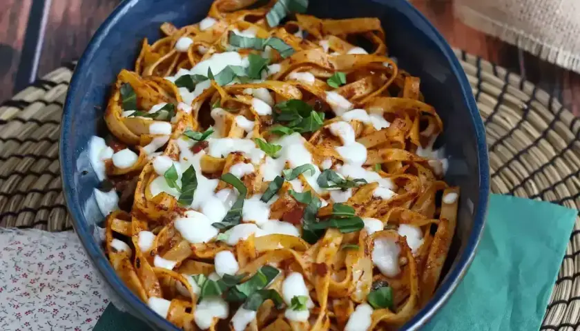 Pyszny makaron z sosem pomidorowym i mozzarellą, posypany bazylią. Idealny obiad na szybko.