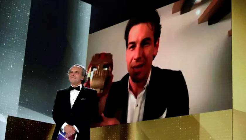 Presentador en los Goya con Mario Casas en pantalla, quien sostiene un premio.