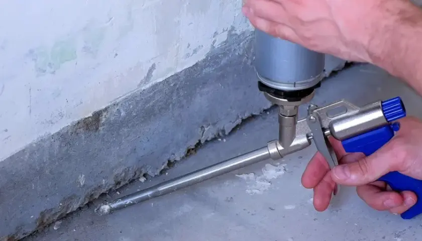Schaumstoff wird mit einer Pistole in eine Fuge gesprüht. So schließt man Lücken, was ist eine Hohlkehle?