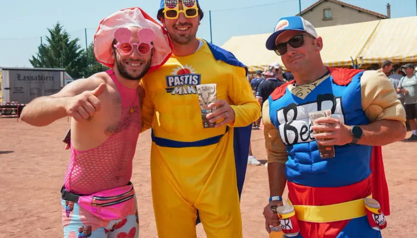 Trois amis costumés pour une soiree brasero, l'un en rose flashy, l'autre en "Pastis Man" jaune, et le dernier en super-héros "Beer".
