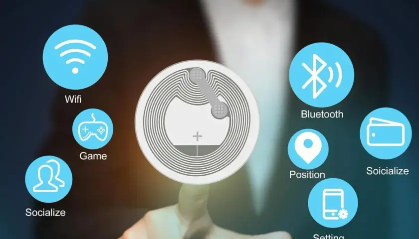 Un dedo toca un chip NFC que muestra iconos de Wifi, Bluetooth, juegos, redes sociales, posición, billetera y configuración.