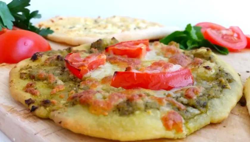 En läcker manakish ost med pesto och tomater, redo att avnjutas.