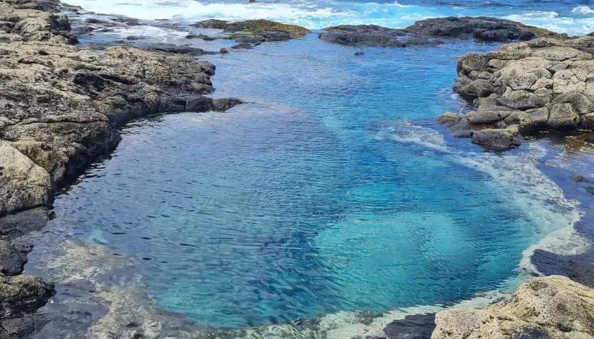 Charcones naturales de Lanzarote, piscinas de agua cristalina entre rocas volcánicas y el azul intenso del océano Atlántico.