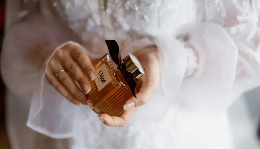Dłonie trzymają buteleczkę perfum Chloé, idealną do ślubnego rankingu perfum damskich.