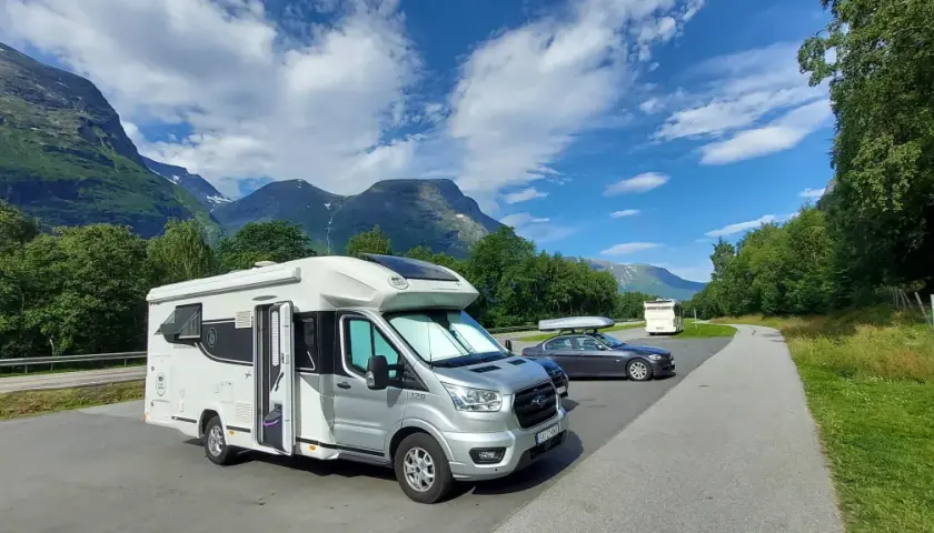 Kamper i Norwegii, piękne góry i błękitne niebo. Zastanawiasz się, ile pieniędzy na wyjazd do Norwegii?