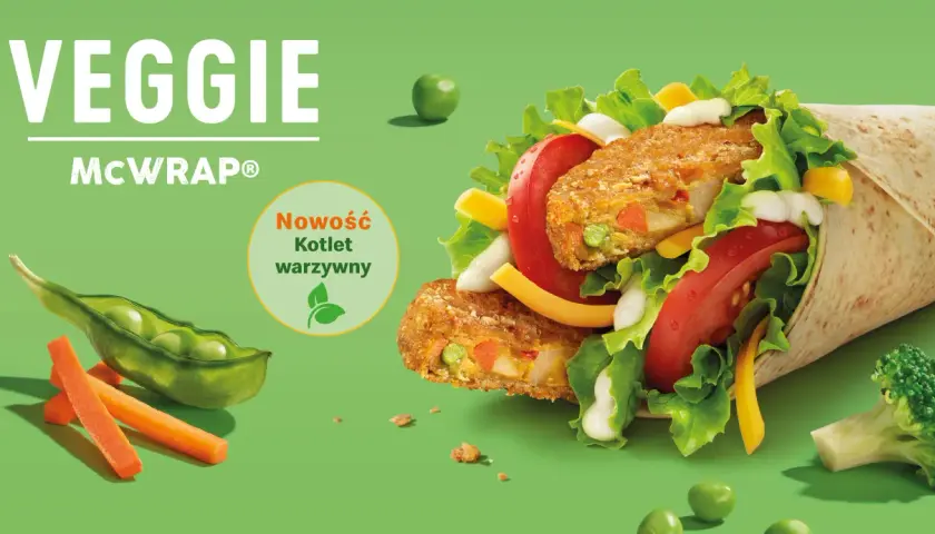 Veggie McWrap z kotletem warzywnym, sałatą, pomidorem, serem i sosem. Widać też groszek, marchewkę i brokuł.