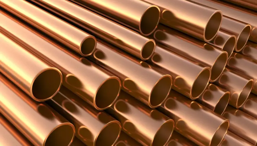 Stosowanie brązu w instalacjach wodnych i grzewczych. Metaliczne rury miedziane ułożone równolegle, tworzące teksturę.
