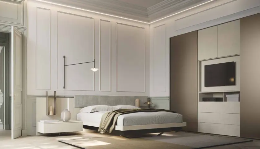 Modern bedroom with a bed, nightstand, wardrobe with TV, and elegant wall paneling.