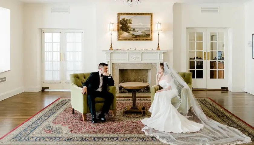 Para młoda siedzi naprzeciwko siebie w eleganckich fotelach. Zastanawiają się, ile trwa ślub cywilny, zanim rozpoczną swoją wspólną podróż.