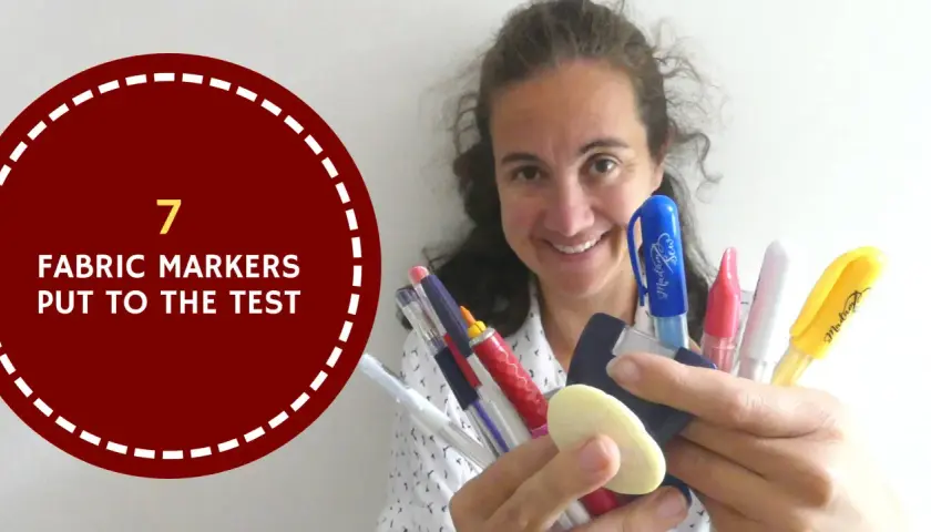A woman smiles, holding a collection of colorful marking tools for sewing, ready to put them to the test.