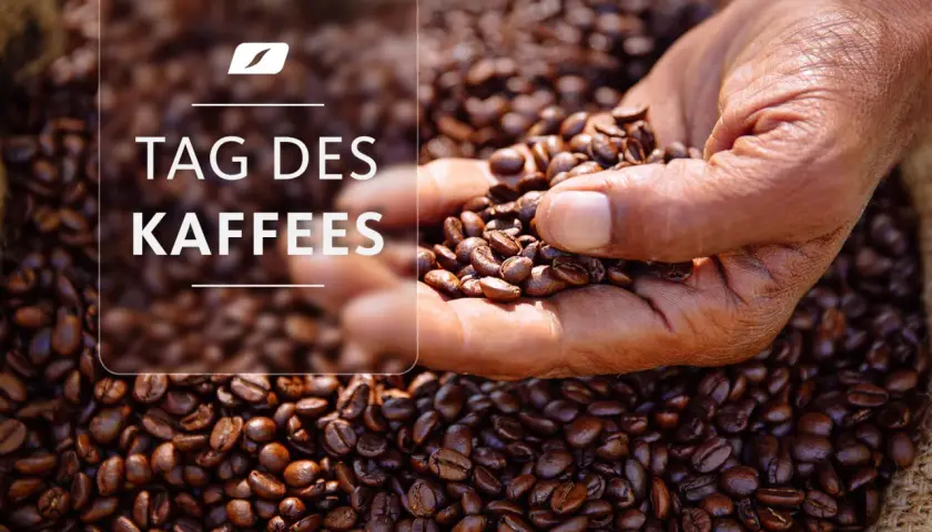 Eine Hand hält geröstete Kaffeebohnen vor einem Sack voller Bohnen. Der Text "TAG DES KAFFEES" ist überlagert.