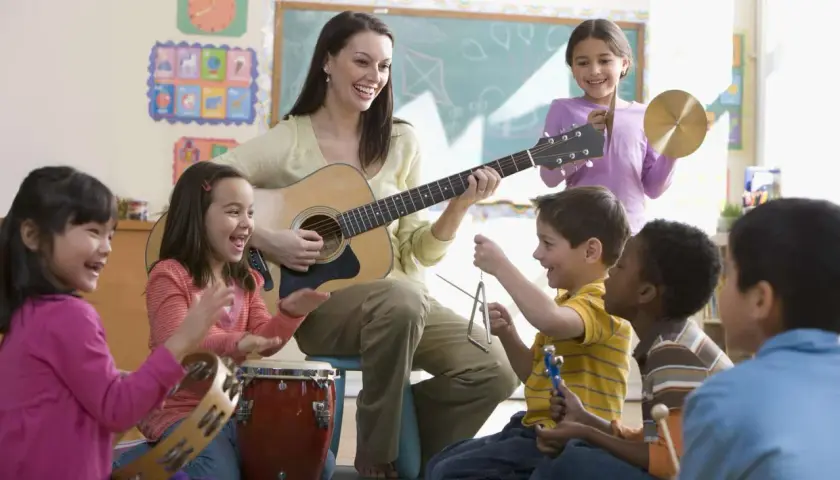 Niños y maestra disfrutan tocando instrumentos y cantando alegres canciones sobre el invierno.