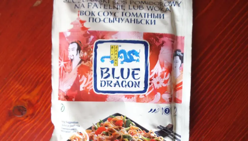 Sos seczuański Blue Dragon z pomidorami, idealny do dań z woka. Na opakowaniu smok i postacie z Azji.
