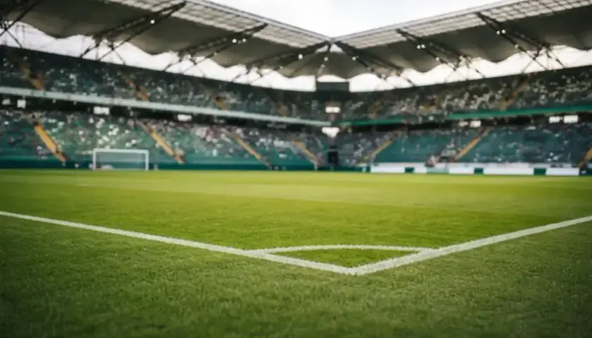 Piłkarskie boisko ze stadionem w tle, gotowe na decydujący mecz barażowy.