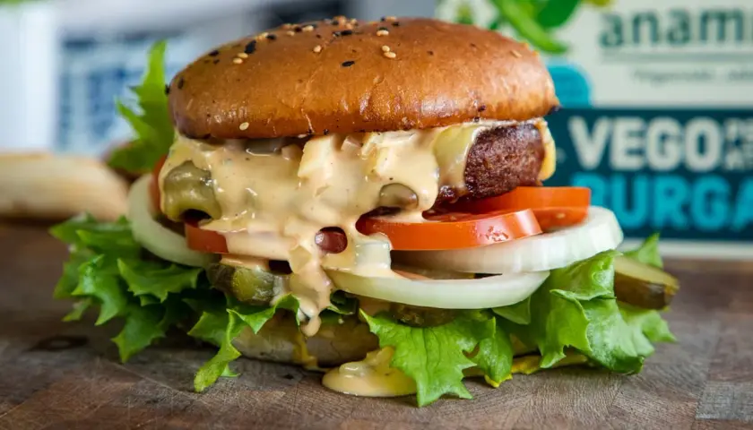 En saftig vegansk burgare med sallad, tomat, lök och picklad gurka, generöst toppad med krämig dressing. Perfekt för ett gott hamburgerdressing recept.