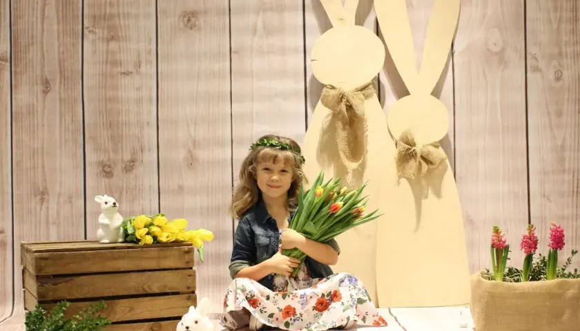 Dziewczynka z bukietem tulipanów i wiankiem na głowie, w tle wielkanocne zające. To piękna Wielkanoc w Polsce!