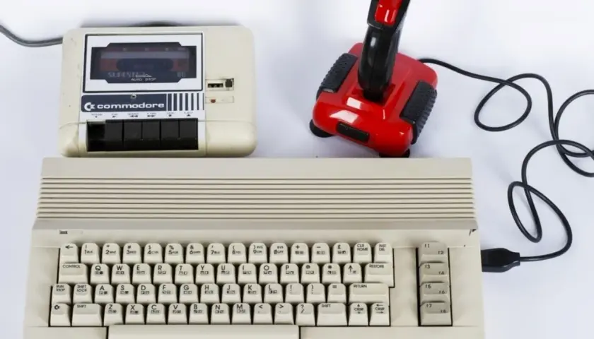 Commodore 64 z magnetofonem i joystickiem, idealny do tworzenia muzyki elektronicznej lat 80. zespoły.