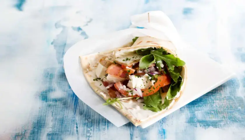 En gyros med fetaost, tomat, lök och ruccola. Vissa religioner anser att fläsk är haram, vilket betyder förbjudet.