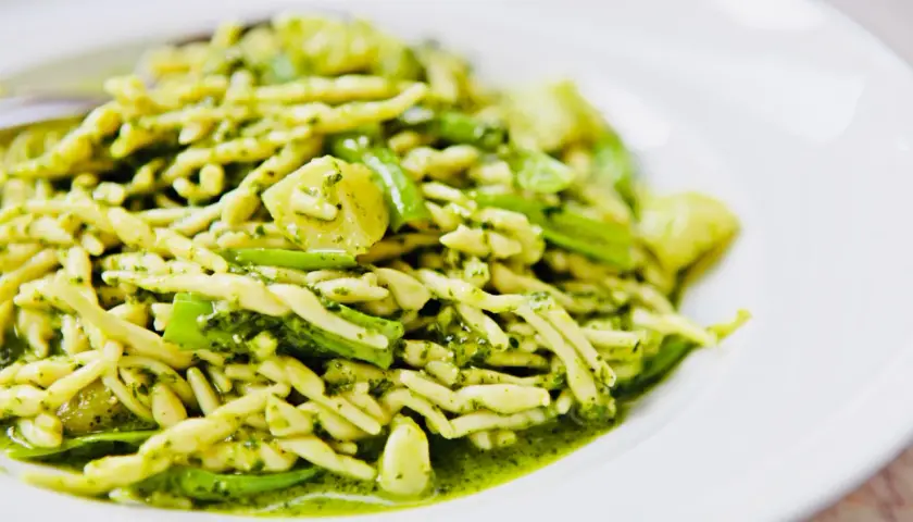 Leckere Trofie-Rezepte mit Pesto und grünen Bohnen auf einem weißen Teller.