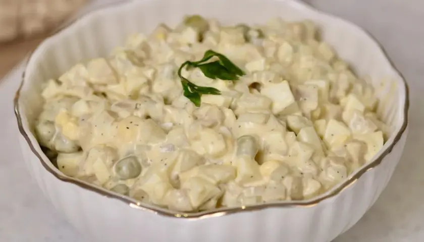 Pyszna sałatka z pieczarkami, jajkiem i groszkiem, polana kremowym sosem. Idealna na każdą okazję.