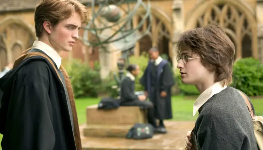 Robert Pattinson jako Cedric Diggory rozmawia z Harrym Potterem na dziedzińcu Hogwartu.