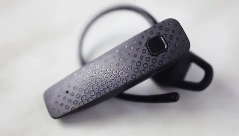 Czarna słuchawka Bluetooth z teksturą kółek. Dowiedz się, jak sparować słuchawki z telefonem.