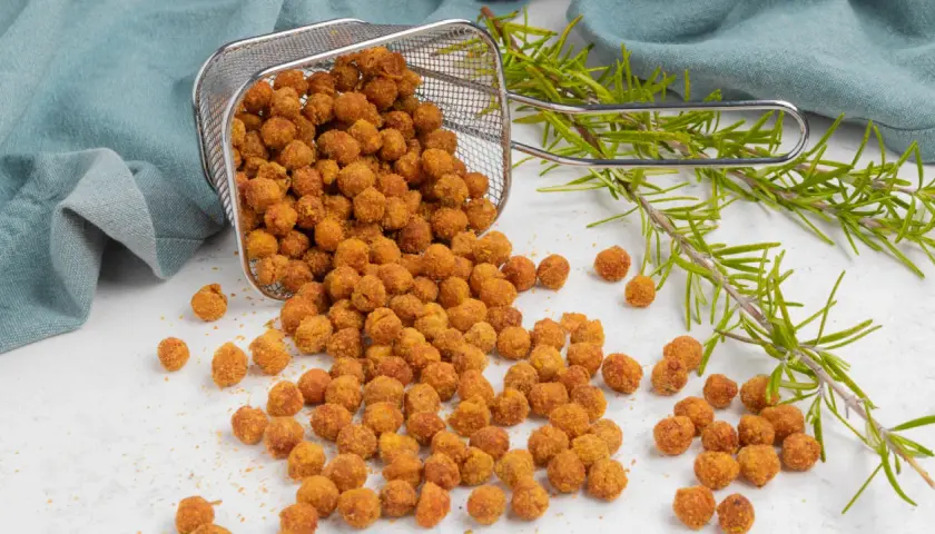 Ceci croccanti in friggitrice ad aria, appena usciti dal cestello, con rametti di rosmarino.