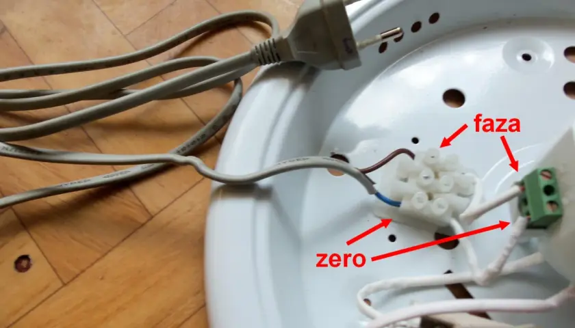 Lampa led z czujnikiem ruchu nie świeci. Widoczne przewody fazy i zera podłączone do złączki.